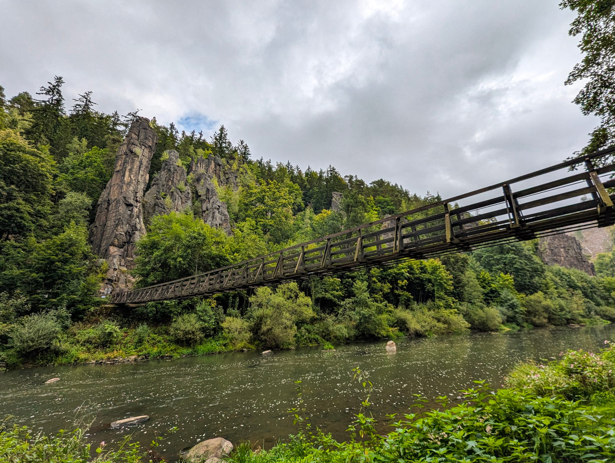 Eine Flusslandschaft mit Felsen und Hängebrücke.