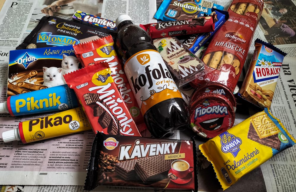 Packungen mit Waffeln, Schokolade sowie eine Colaflasche auf einem Tisch.