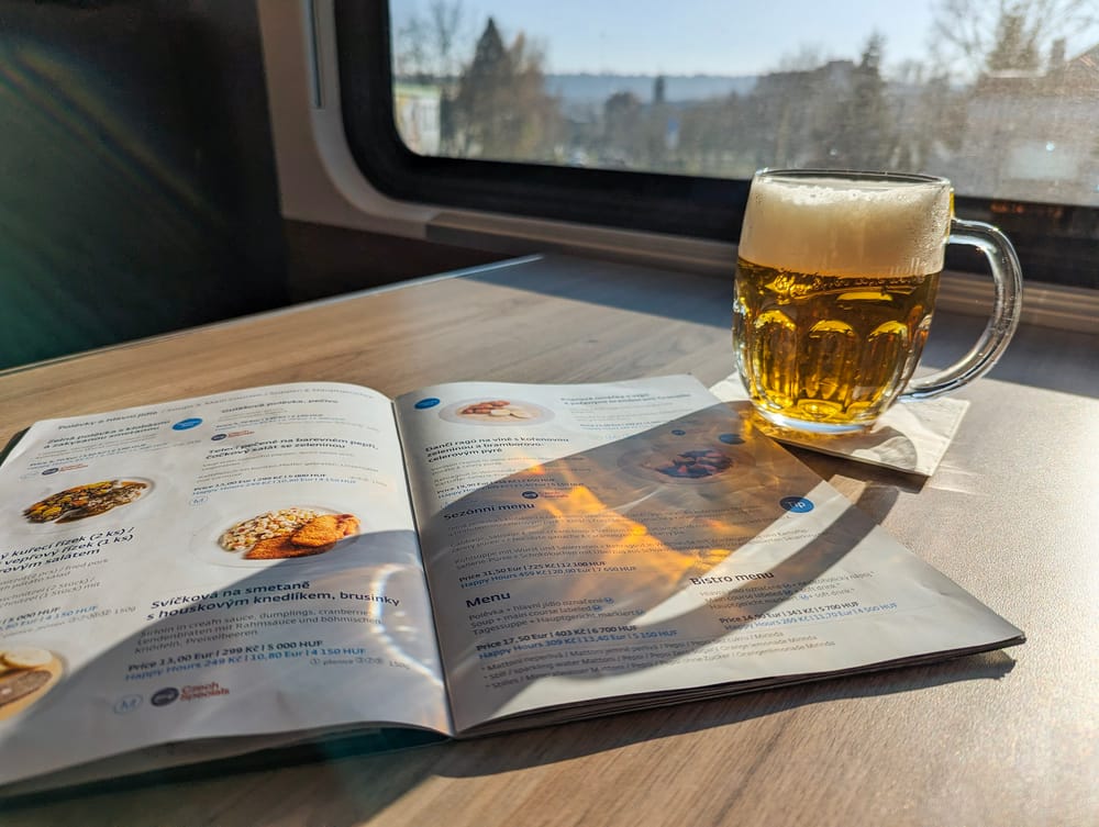 Ein Glas Bier steht auf einem Tisch in einem Speisewagen.