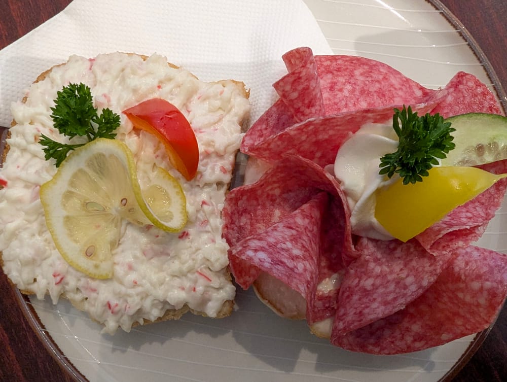 Zwei belegte Weißbrotscheiben auf einem Teller.